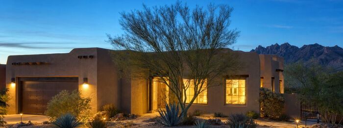 Southwestern stucco home lit up at dusk